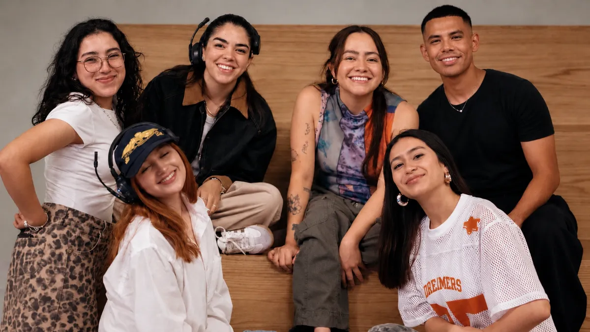 Seis jóvenes del equipo de Mosaic México sonríen juntos sentados en una banca de madera en Distrito Polanco