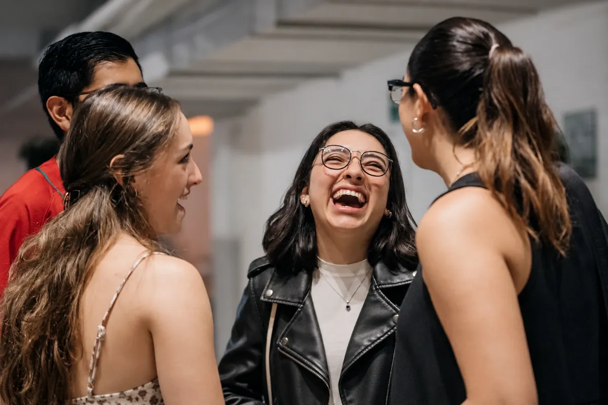 Tres amigas ríen juntas durante una reunión de Mosaic México en Distrito Polanco